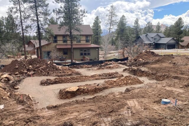 a house with a lot of dirt and trees