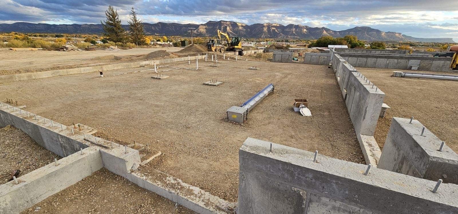 a construction site with a bulldozer and a mountain in the background